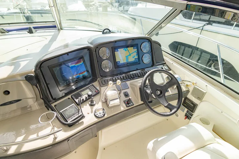 Slide: The Image of Cockpit of 2005 Sea Ray 420 Sundancer with navigation screens and steering wheel. - 26