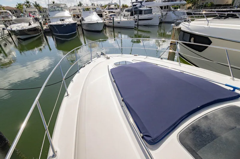 Slide: The Image of 2005 Sea Ray 420 Sundancer yacht docked in a marina, surrounded by other boats. - 34
