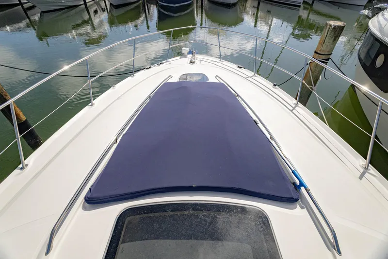 Slide: The Image of 2005 Sea Ray 420 Sundancer yacht bow with blue cover, docked in marina. - 35