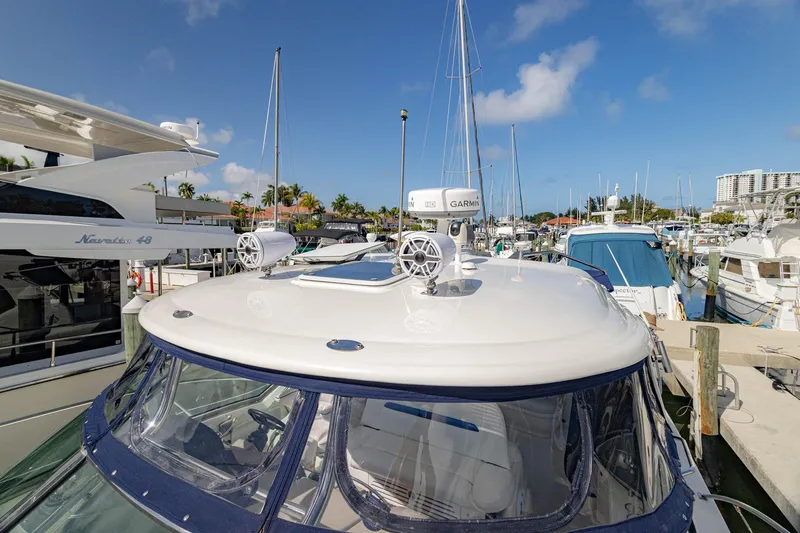 Slide: The Image of 2005 Sea Ray 420 Sundancer yacht docked at marina under clear blue sky. - 39