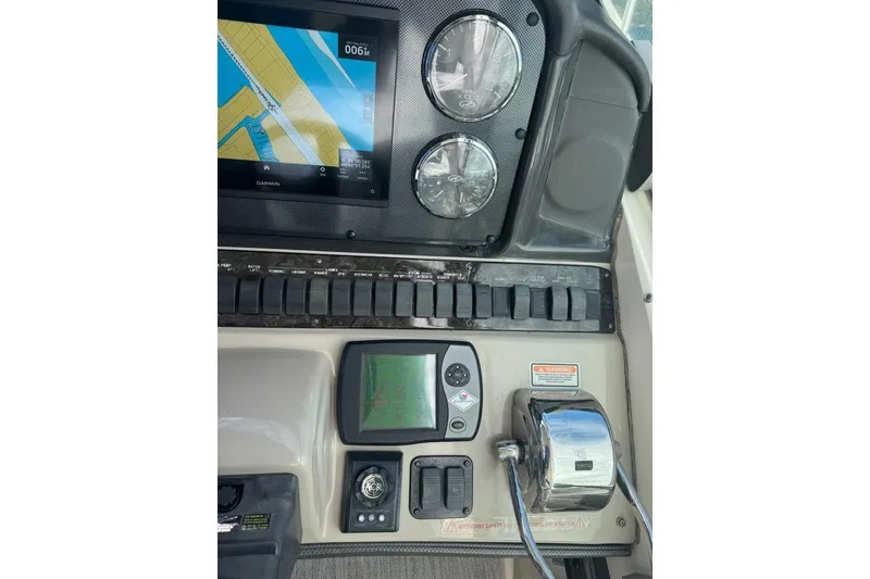 Slide: The Image of Control panel of a 2005 Sea Ray 420 Sundancer with navigation and throttle controls. - 7