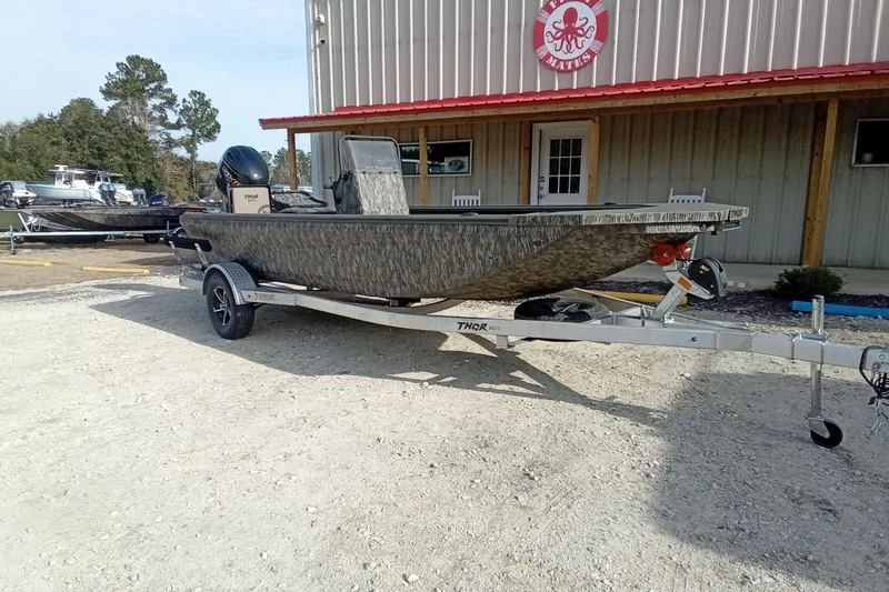 Slide: The Image of 2026 Thor 1900 Low Country Elite boat on trailer outside a building. - 2