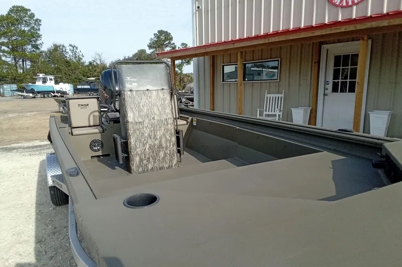 Slide: The Image of 2026 Thor 1900 Low Country Elite boat parked outside a building. - 5