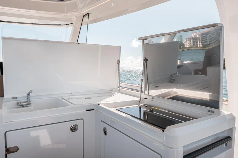 Slide: The Image of 2024 Fjord Boats 53XL yacht kitchen area with sink and stove, overlooking the ocean. - 19