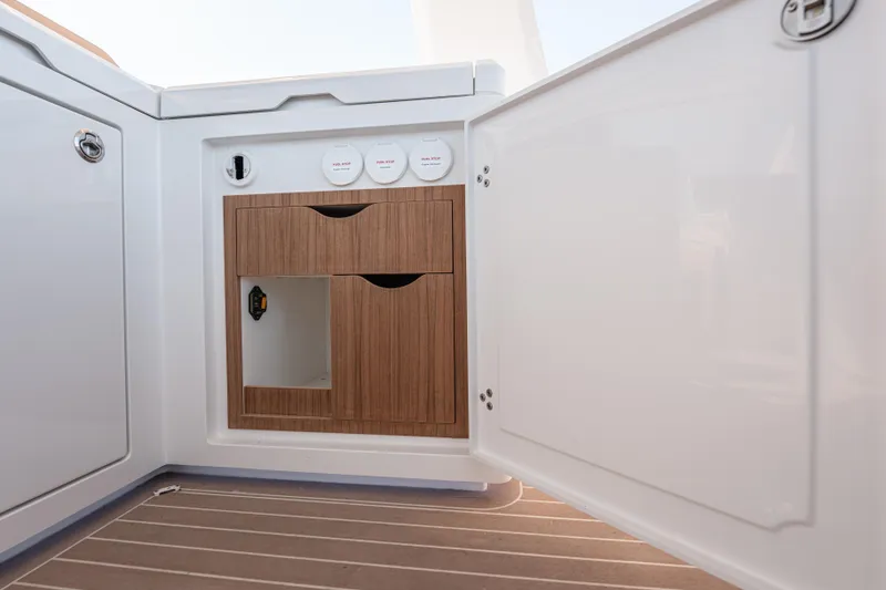 Slide: The Image of 2024 Fjord Boats 53XL interior cabinet with wooden drawers and white paneling. - 21