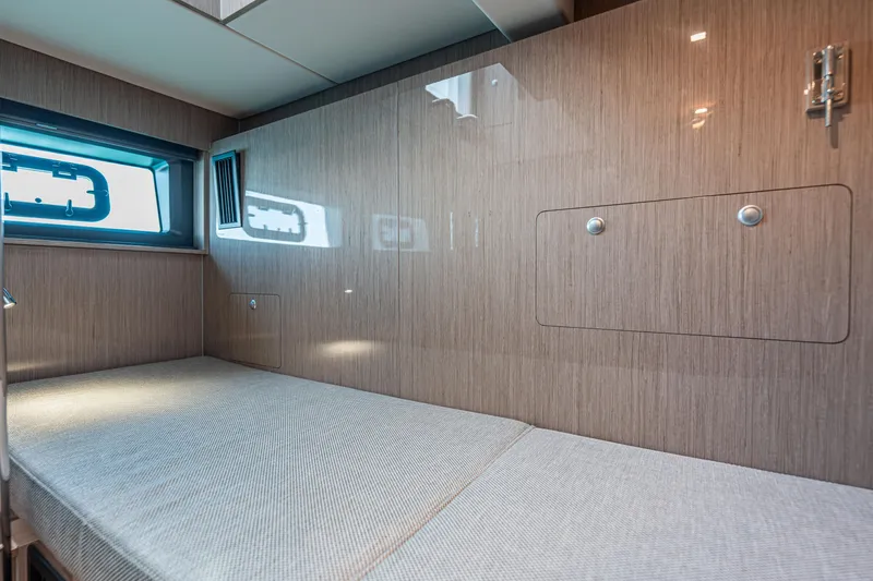 Slide: The Image of 2024 Fjord Boats 53XL cabin interior with sleek wood paneling and comfortable bedding. - 44