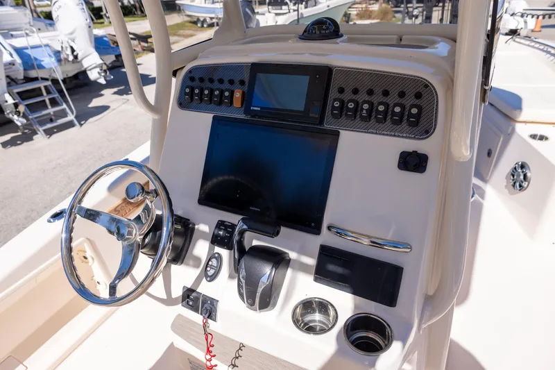 Slide: The Image of 2021 Grady-White 251 Coastal Explorer boat dashboard with steering wheel and navigation controls. - 11