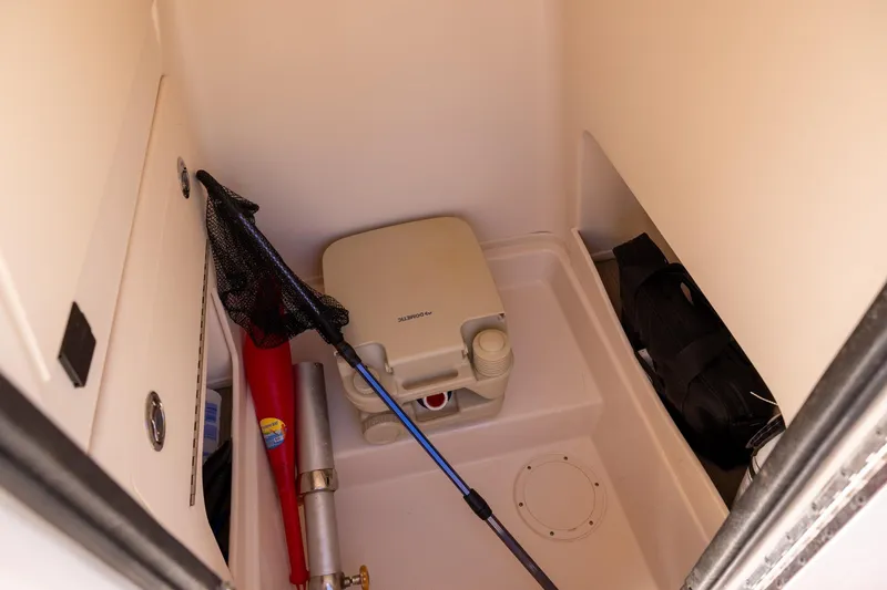 Slide: The Image of 2021 Grady-White 251 Coastal Explorer storage area with portable toilet and fishing gear. - 16