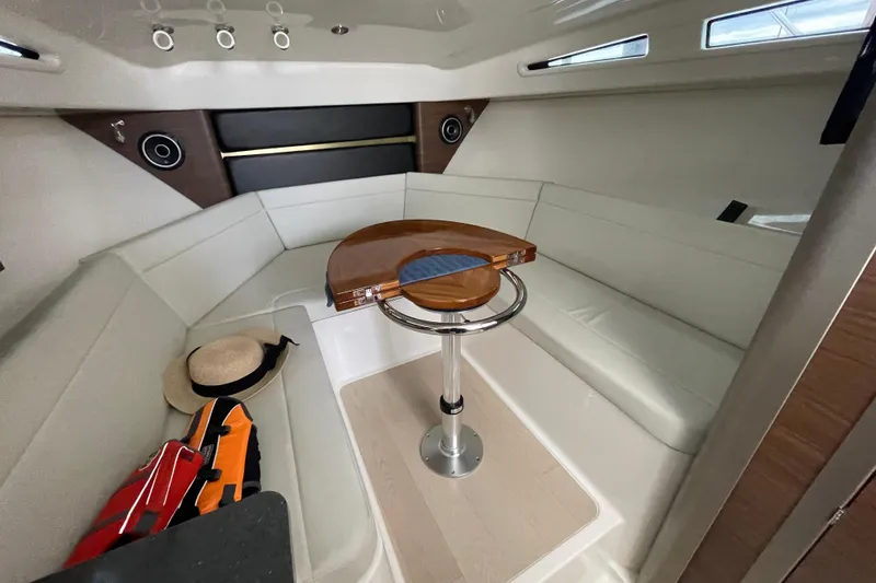 Slide: The Image of 2023 Boston Whaler 325 Conquest cabin interior with seating, table, and accessories. - 14