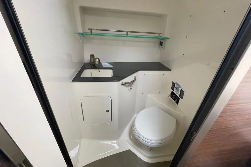 Slide: The Image of 2023 Boston Whaler 325 Conquest bathroom with sink, toilet, and storage shelf. - 15