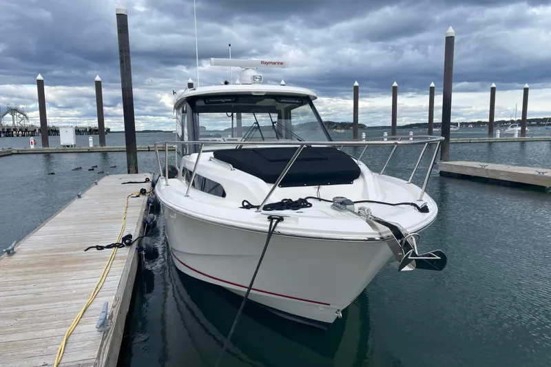 Slide: The Image of 2023 Boston Whaler 325 Conquest docked at marina under cloudy sky. - 3