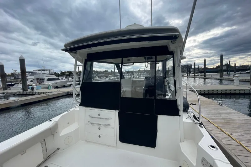 Slide: The Image of 2023 Boston Whaler 325 Conquest docked at marina under cloudy sky. - 6
