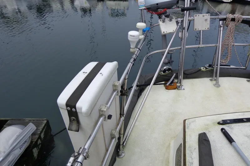 Slide: The Image of 1979 Islander Freeport Center Cockpit Ketch deck with railing and equipment by the water. - 15