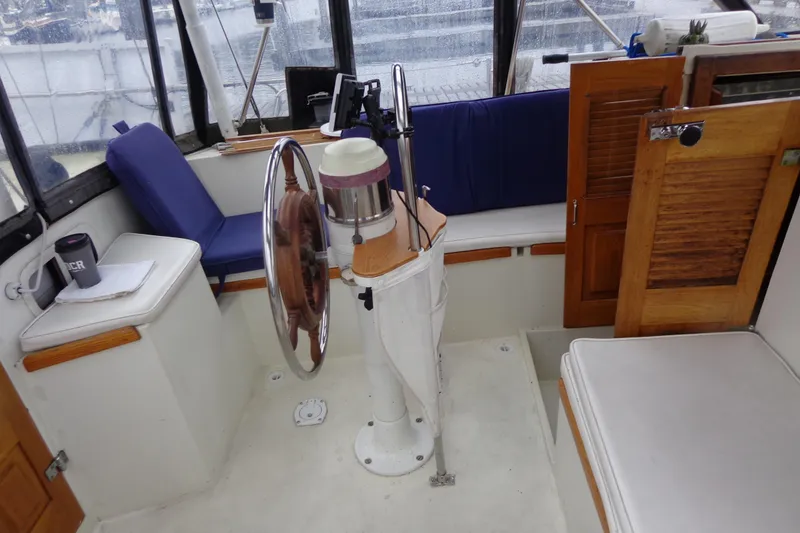 Slide: The Image of 1979 Islander Freeport Center Cockpit Ketch interior with wooden helm and seating. - 25