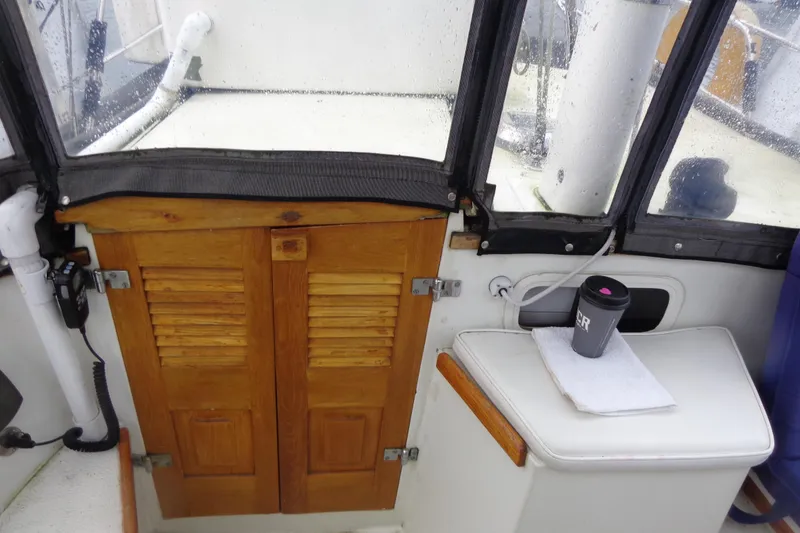 Slide: The Image of 1979 Islander Freeport Center Cockpit Ketch interior with wooden doors and a cup on a table. - 26