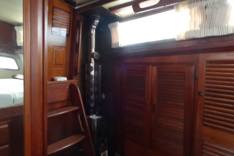 Slide: The Image of Interior of 1979 Islander Freeport Center Cockpit Ketch with wooden cabinetry and cozy furnishings. - 32