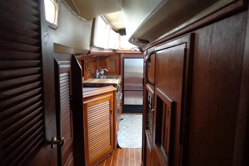 Slide: The Image of Interior of 1979 Islander Freeport Center Cockpit Ketch with wooden cabinetry and compact kitchen. - 34