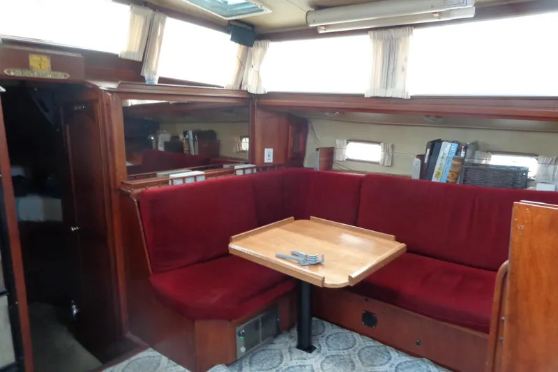 Slide: The Image of Interior of 1979 Islander Freeport Center Cockpit Ketch with red seating and wooden table. - 36