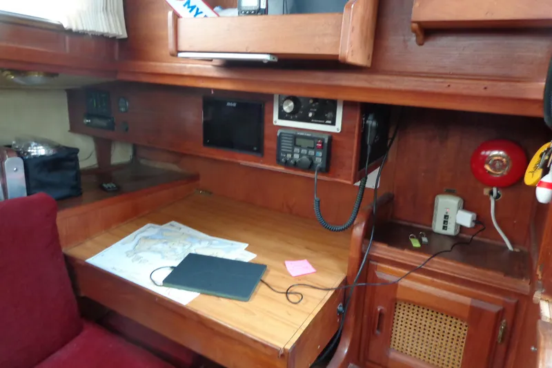 Slide: The Image of Navigation station inside 1979 Islander Freeport Center Cockpit Ketch with maps and communication equipment. - 38