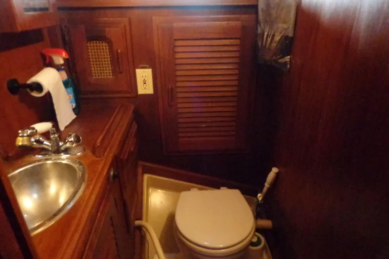 Slide: The Image of 1979 Islander Freeport Center Cockpit Ketch bathroom with wooden cabinetry and compact toilet. - 41