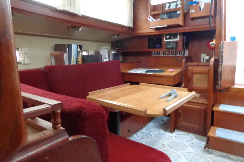 Slide: The Image of Interior of 1979 Islander Freeport Center Cockpit Ketch with red seating and wooden table. - 42