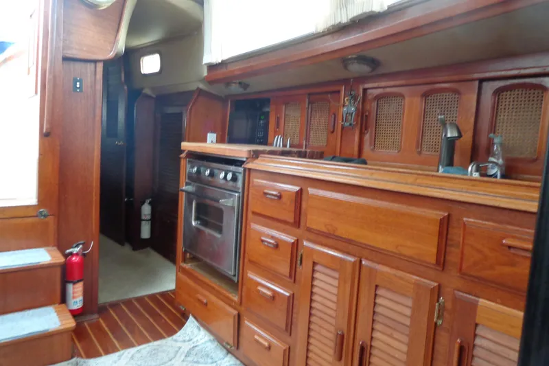 Slide: The Image of Interior of 1979 Islander Freeport Center Cockpit Ketch with wooden cabinetry and kitchen amenities. - 43
