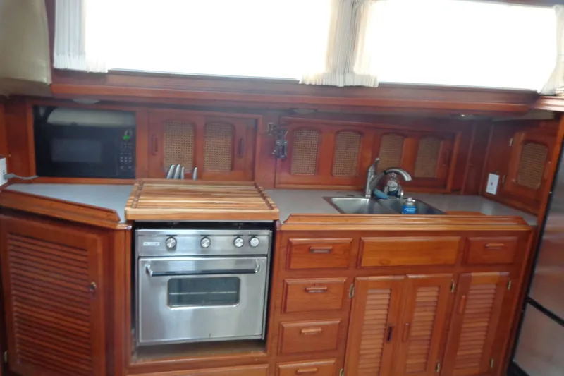 Slide: The Image of 1979 Islander Freeport Center Cockpit Ketch kitchen with wood cabinetry and stainless steel appliances. - 44