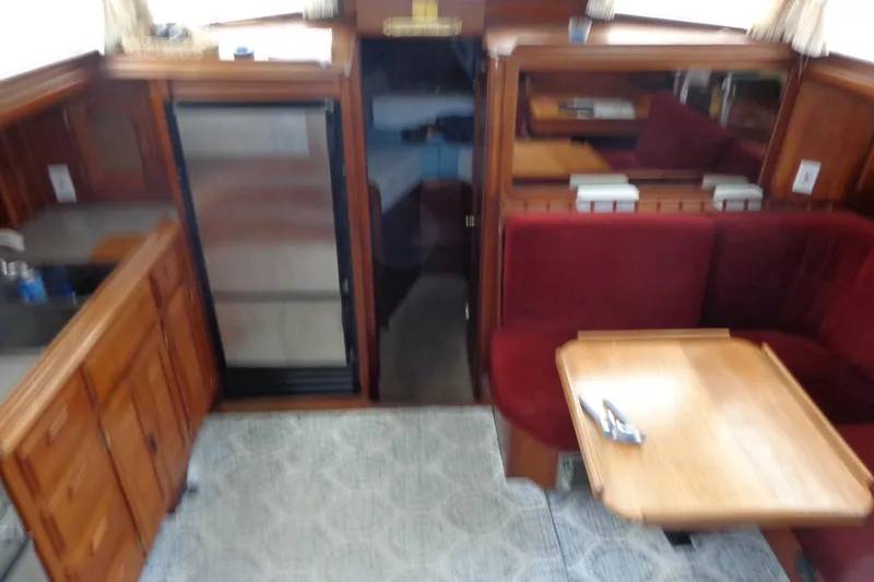 Slide: The Image of 1979 Islander Freeport Center Cockpit Ketch interior with wood cabinetry and red seating. - 45
