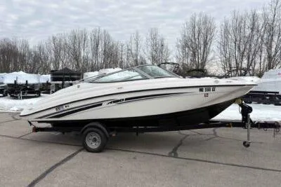 Slide: The Image of 2017 Yamaha Boats SX190 on trailer, parked outdoors with trees in the background. - 2