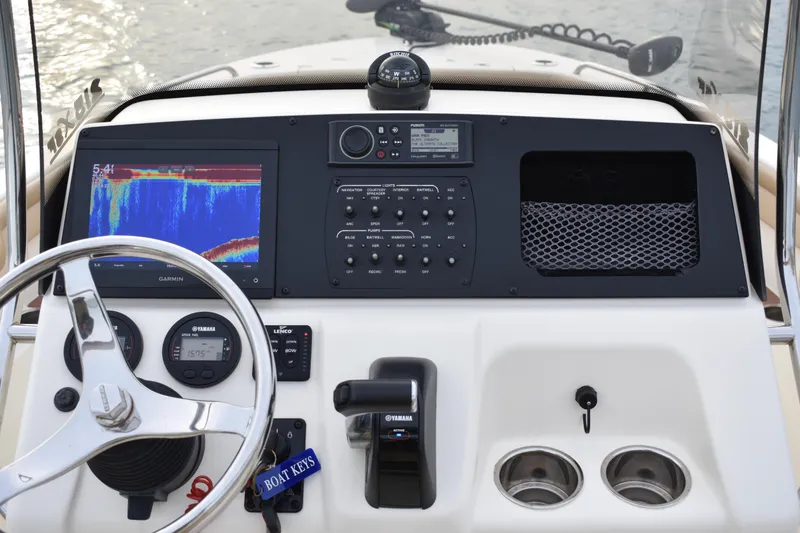 Slide: The Image of 2020 Scout 215 XSF boat interior with beige seating and Yamaha 150 outboard motor. - 15