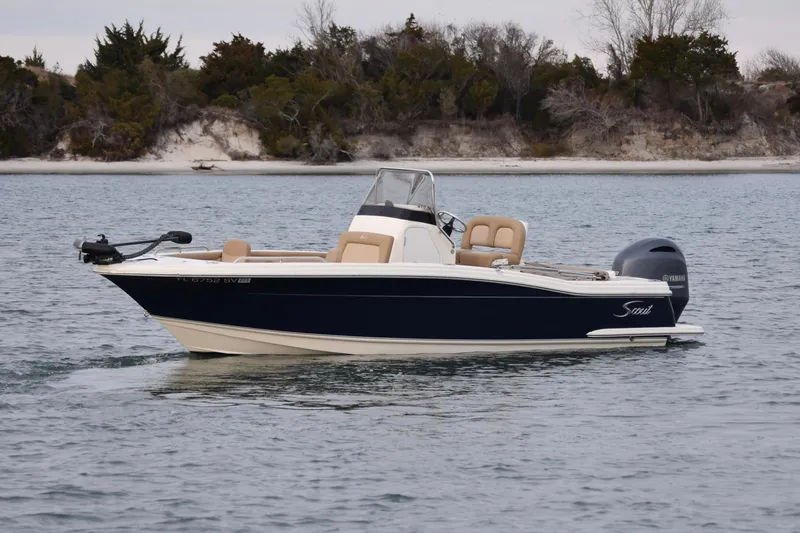 Slide: The Image of 2020 Scout 215 XSF boat on calm water near a sandy shoreline. - 5