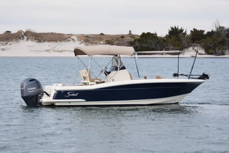 Slide: The Image of 2020 Scout 215 XSF boat on calm water with sandy shoreline background. - 6