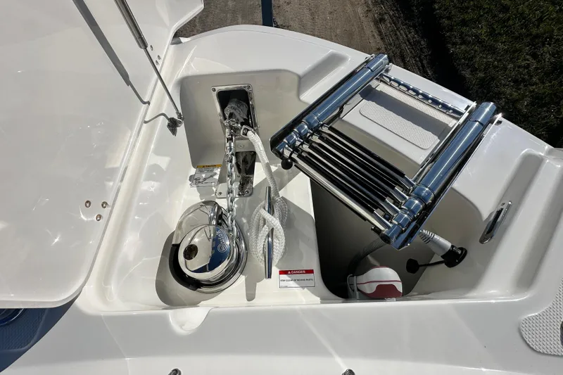 Slide: The Image of Boston Whaler 240 Vantage 2026 anchor compartment with ladder. - 10