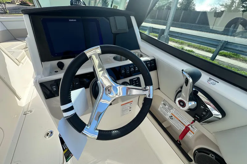 Slide: The Image of Boston Whaler 240 Vantage 2026 helm with steering wheel and controls. - 21