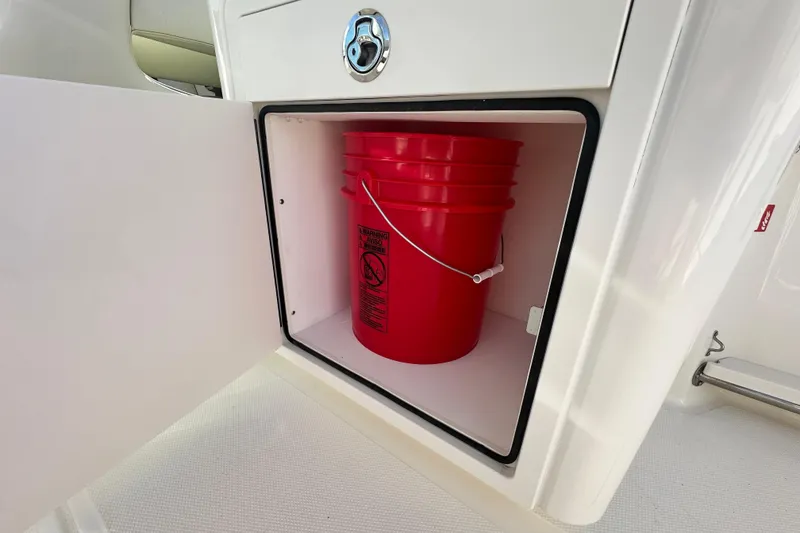 Slide: The Image of Red bucket in storage compartment of 2026 Boston Whaler 240 Vantage. - 31