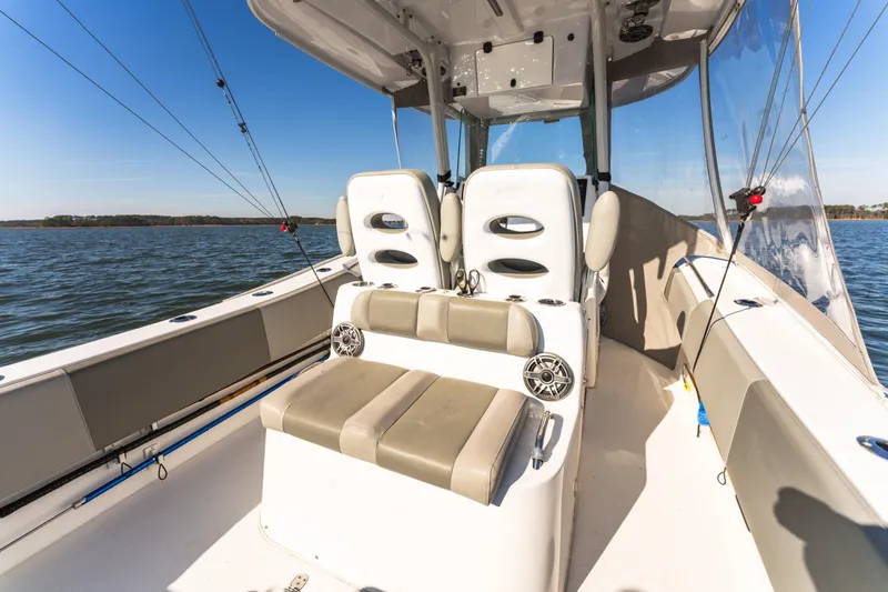 Slide: The Image of 2021 Cape Horn 32 XS boat interior with seating and fishing rods on a sunny day. - 14