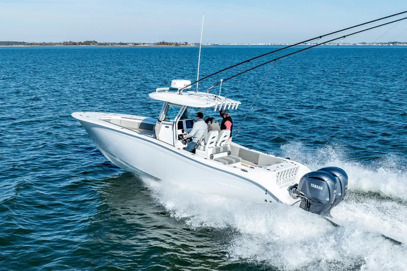 Slide: The Image of 2021 Cape Horn 32 XS boat cruising on open water with Yamaha engines. - 2