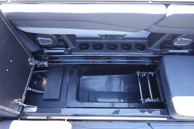 Slide: The Image of 2026 Axis A245 boat interior storage compartment with cup holders and seating. - 26