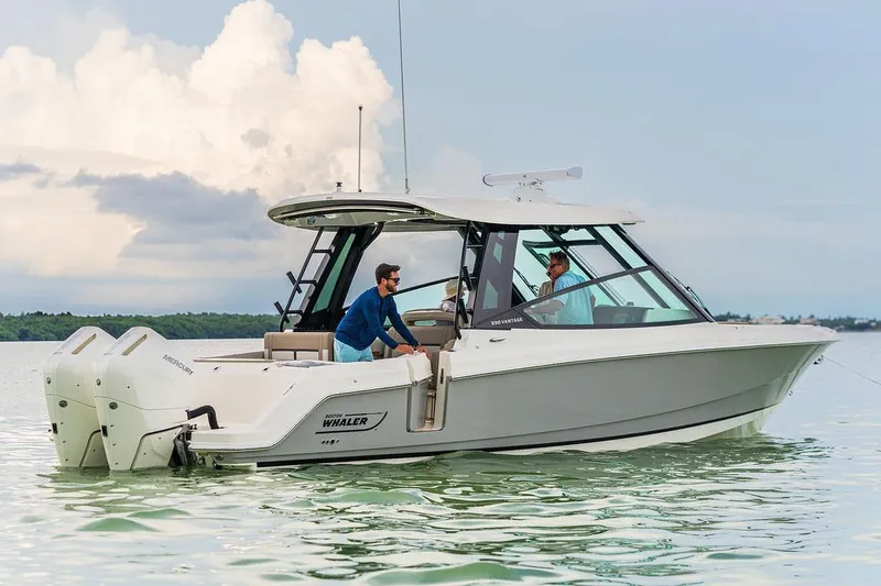 Slide: The Image of Manufacturer Provided Image: 2026 Boston Whaler 330 Vantage boat on calm water with two people onboard. - 2