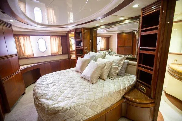 Slide: The Image of Luxurious bedroom interior of 2003 Azimut 74 Solar yacht with elegant wood finishes and plush bedding. - 14
