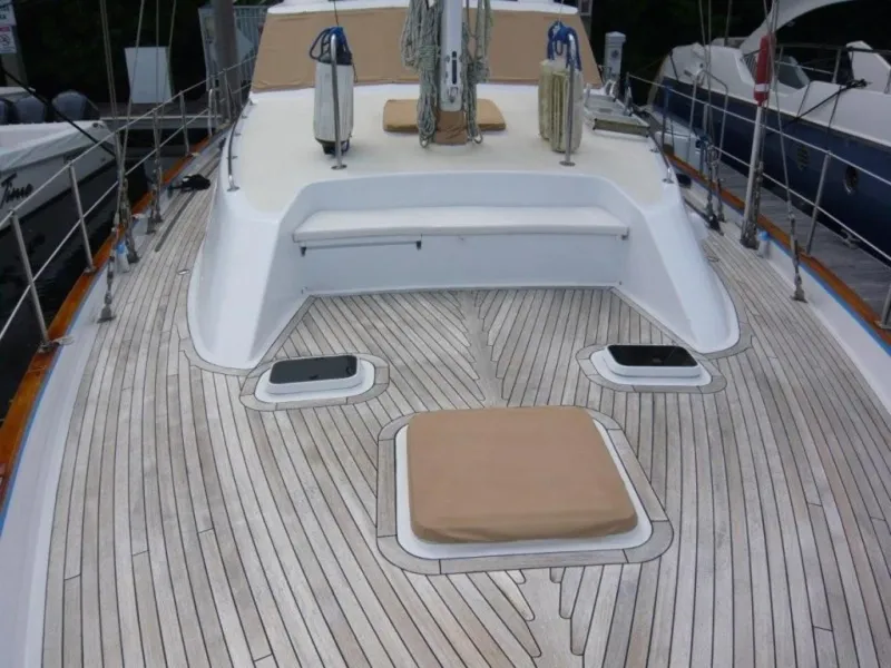 Slide: The Image of 1990 Cheoy Lee Sloop deck with teak flooring and white cabin details. - 11