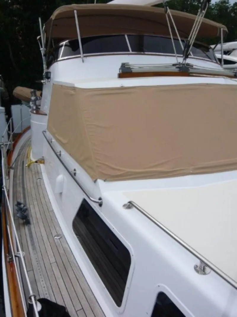 Slide: The Image of 1990 Cheoy Lee Sloop with beige canopy and wooden deck details. - 14