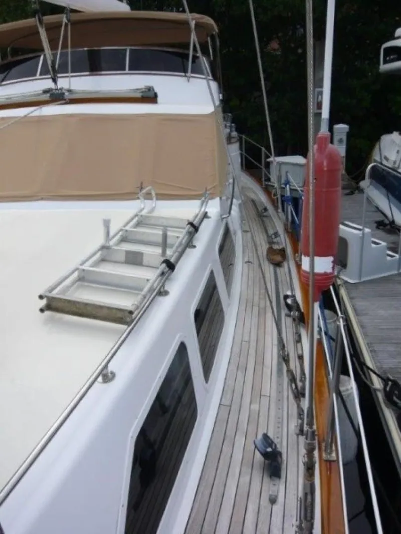 Slide: The Image of 1990 Cheoy Lee Sloop with teak deck and beige canopy, docked at marina. - 15