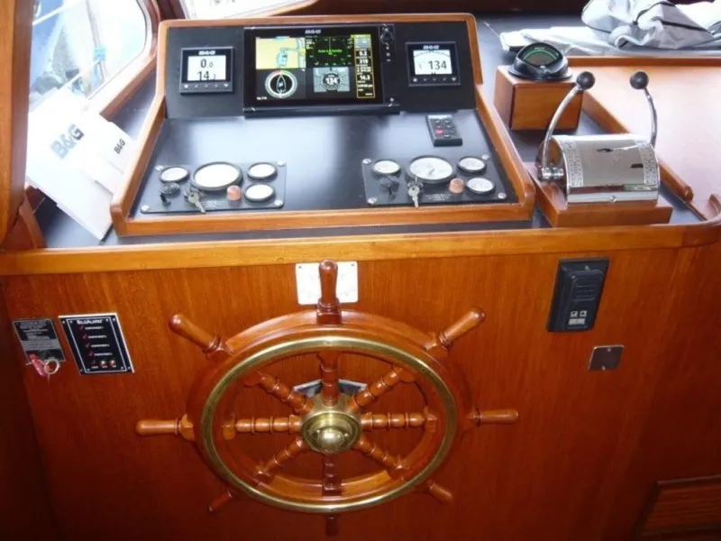 Slide: The Image of 1990 Cheoy Lee Sloop helm with navigation instruments and wooden steering wheel. - 26