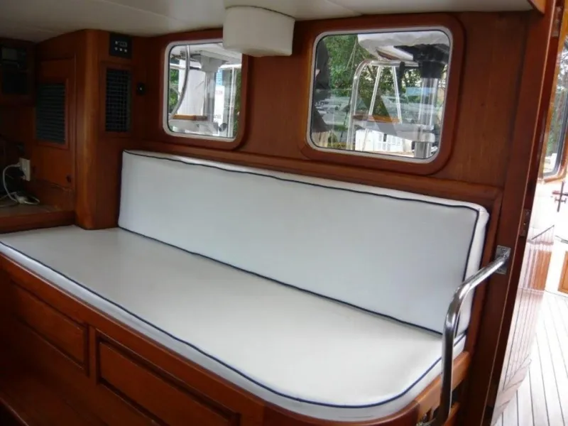 Slide: The Image of Interior of 1990 Cheoy Lee Sloop with white cushioned seating and wooden finish. - 29
