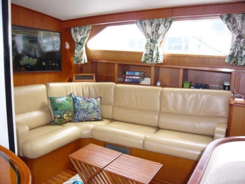 Slide: The Image of Interior of 1990 Cheoy Lee Sloop with beige leather seating and wooden accents. - 35