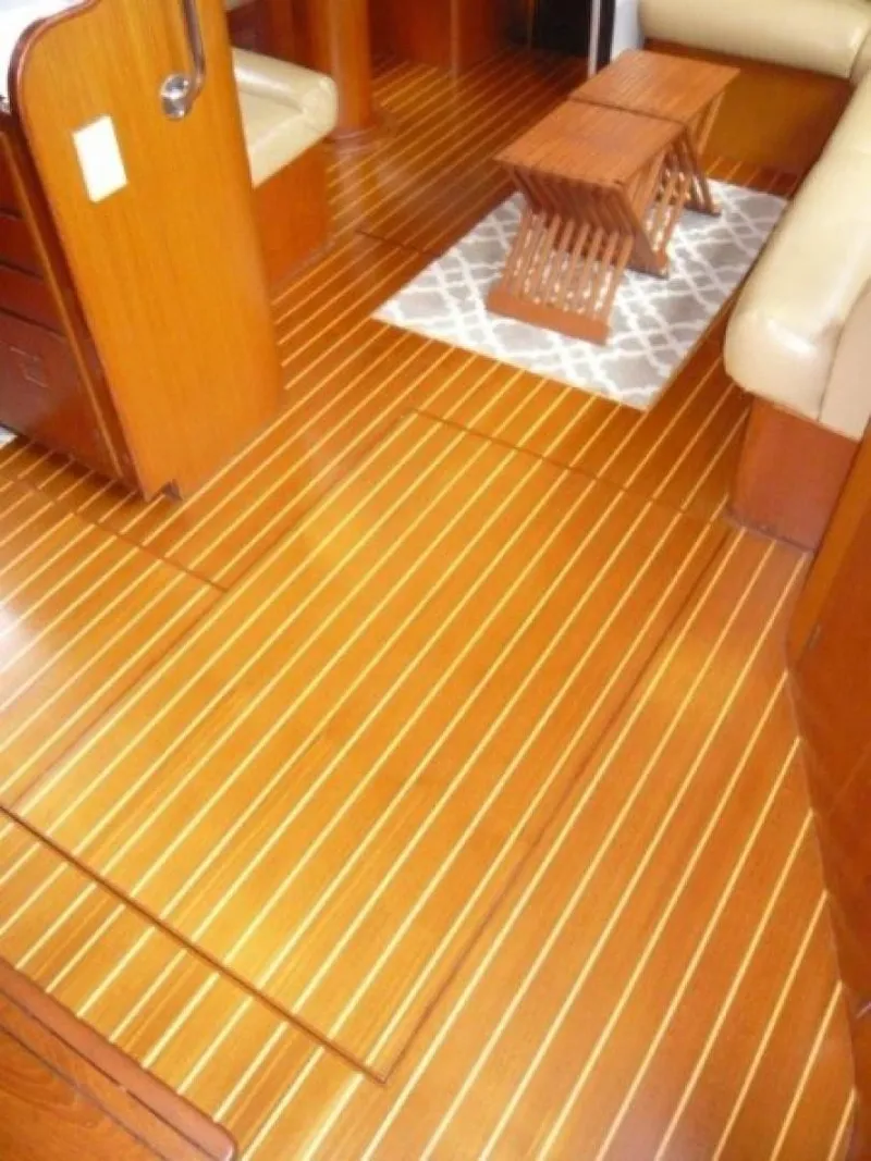 Slide: The Image of Interior of 1990 Cheoy Lee Sloop with polished wooden flooring and compact furniture. - 43