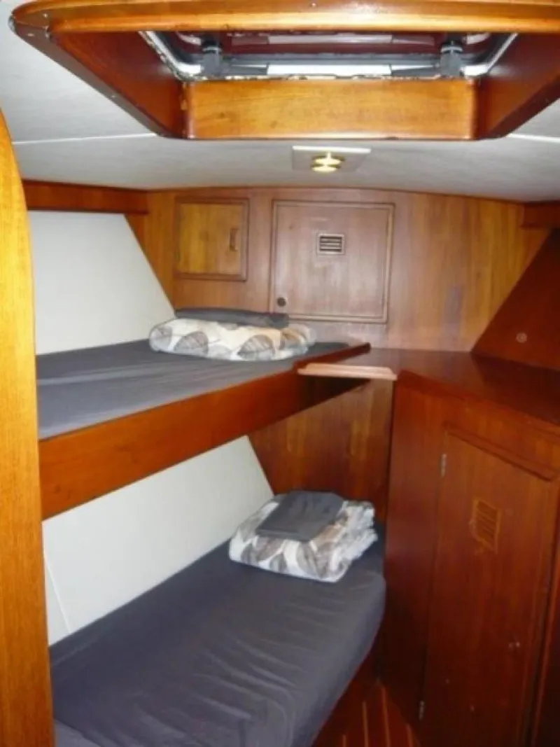 Slide: The Image of 1990 Cheoy Lee Sloop interior with wooden bunk beds and storage cabinets. - 48