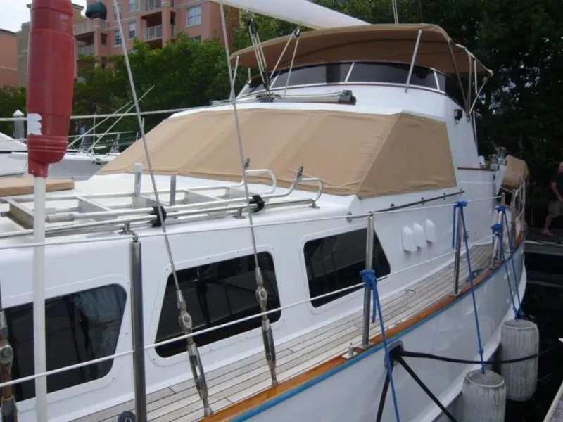 Slide: The Image of 1990 Cheoy Lee Sloop docked, featuring beige canopy and sleek design. - 9