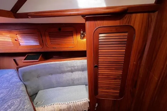 Slide: The Image of Interior of 1988 Hylas Custom 44 sailboat with wood paneling and cozy seating. - 10